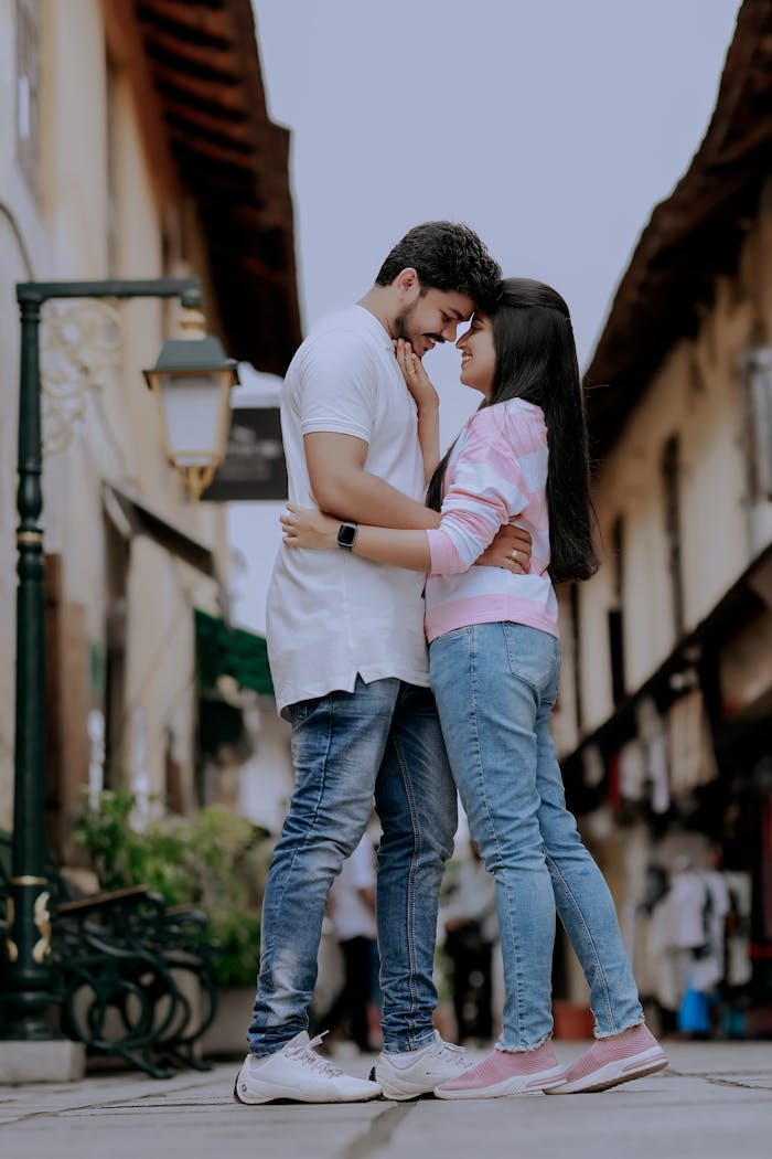 A young couple joyfully embracing on a bustling urban street, radiating happiness and love.